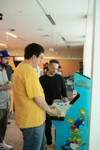 People gathered around arcade game at event